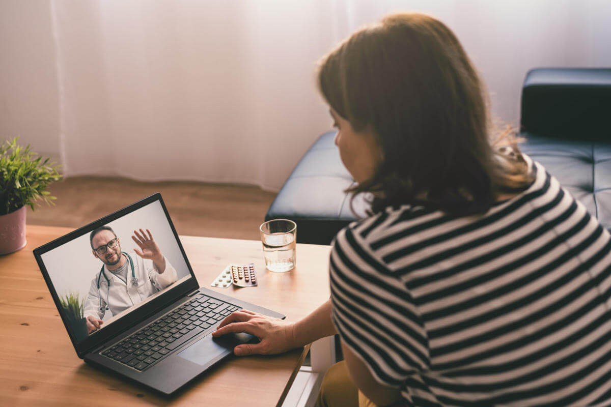 Woman on sofa using laptop for a virtual therapy session