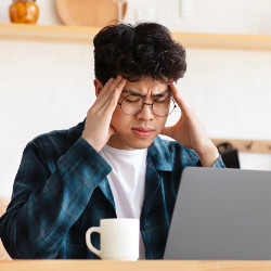 Person experiencing work-related stress and migraines