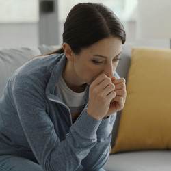 Sad woman sitting on couch at home