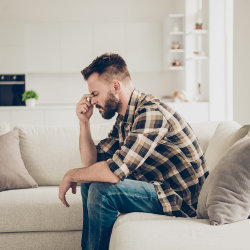Pensive man in brown checkered shirt