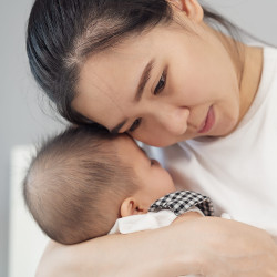 Mother holding newborn baby sleeping in her arms