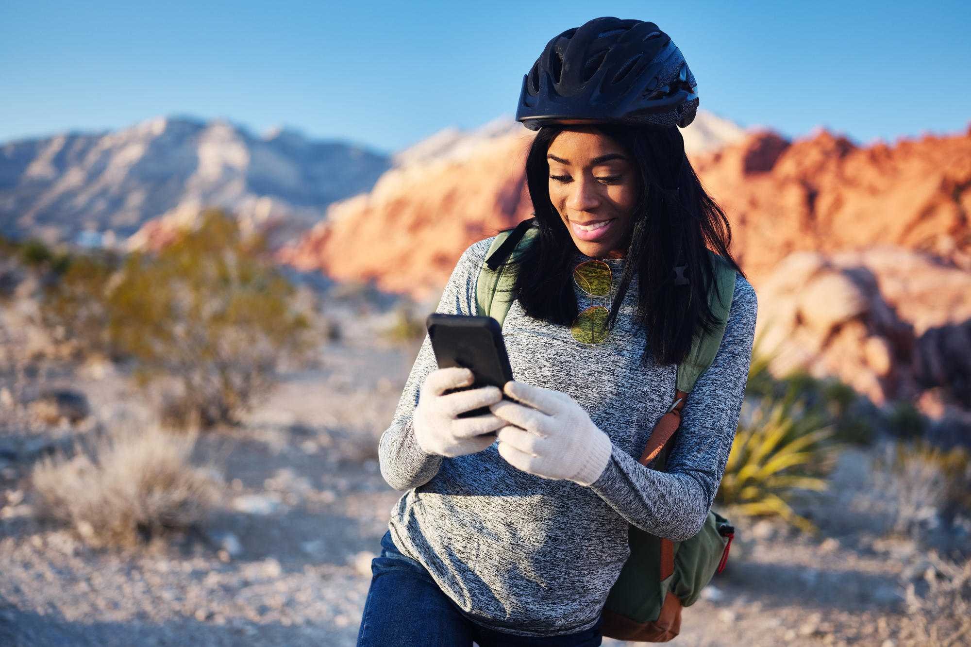 Fit woman on bike taking a rest to use smartphone