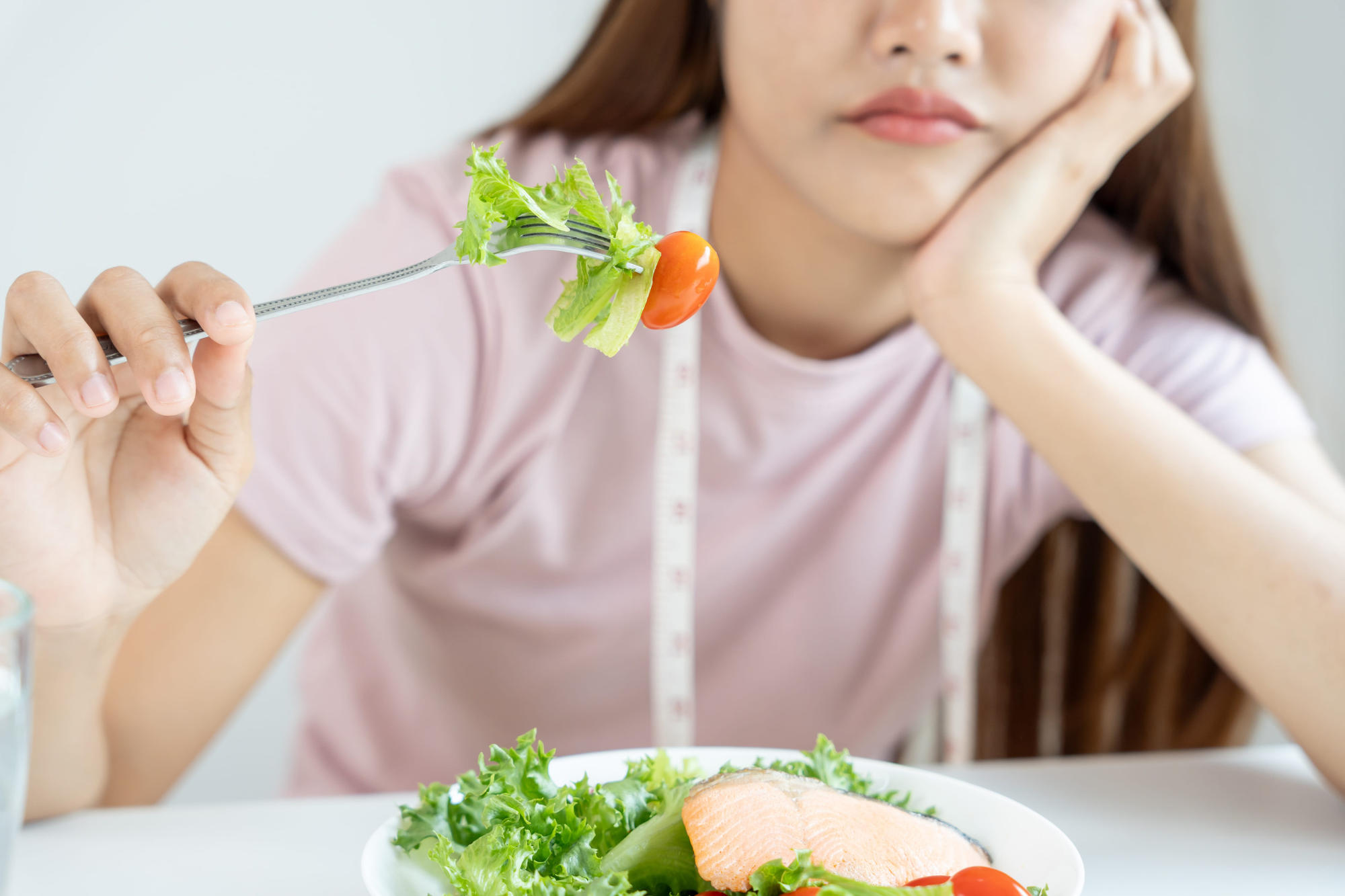 Asian woman choosing low-calorie food for diet
