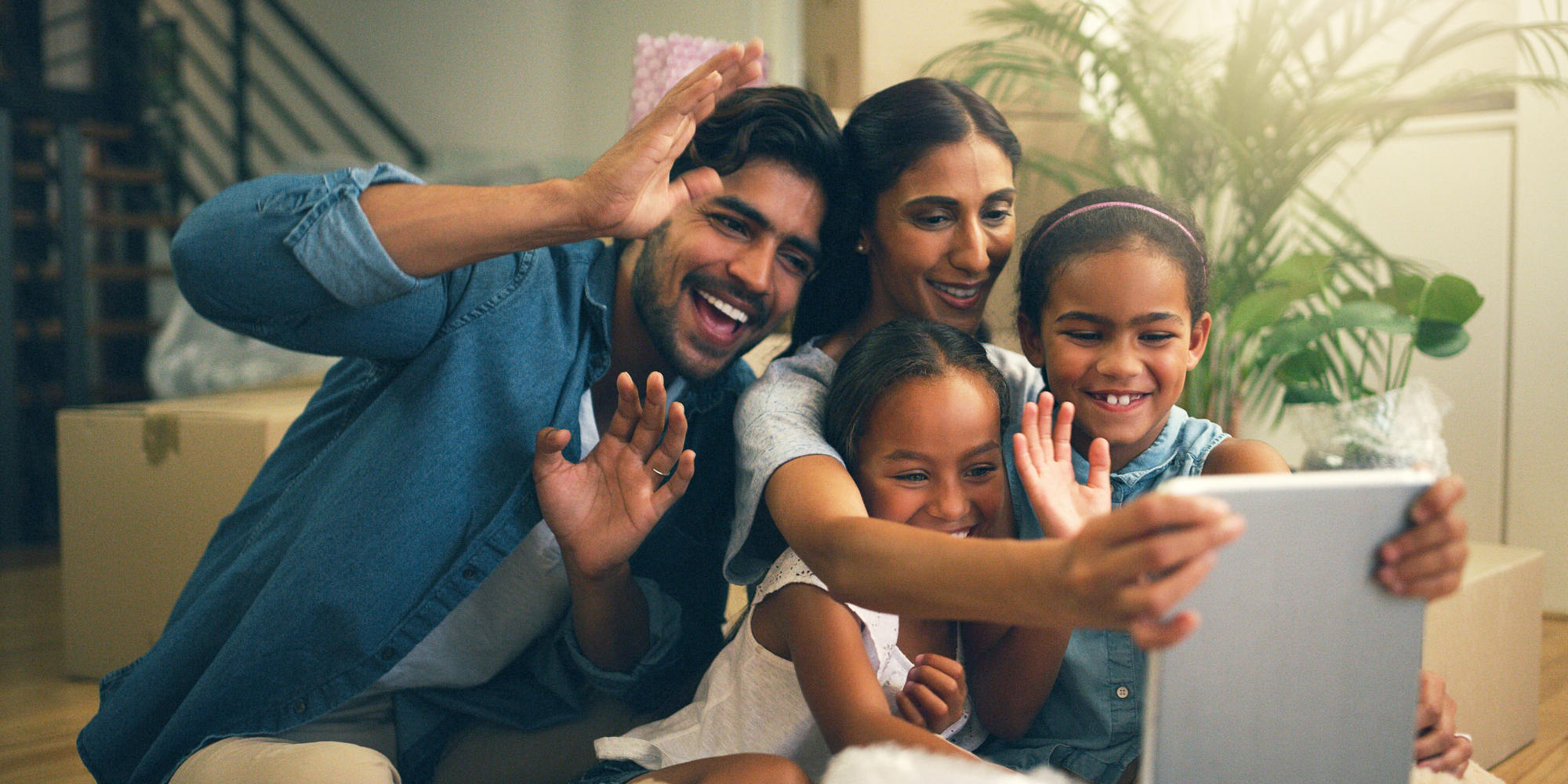 Young family making a video call on tablet to connect with family far away