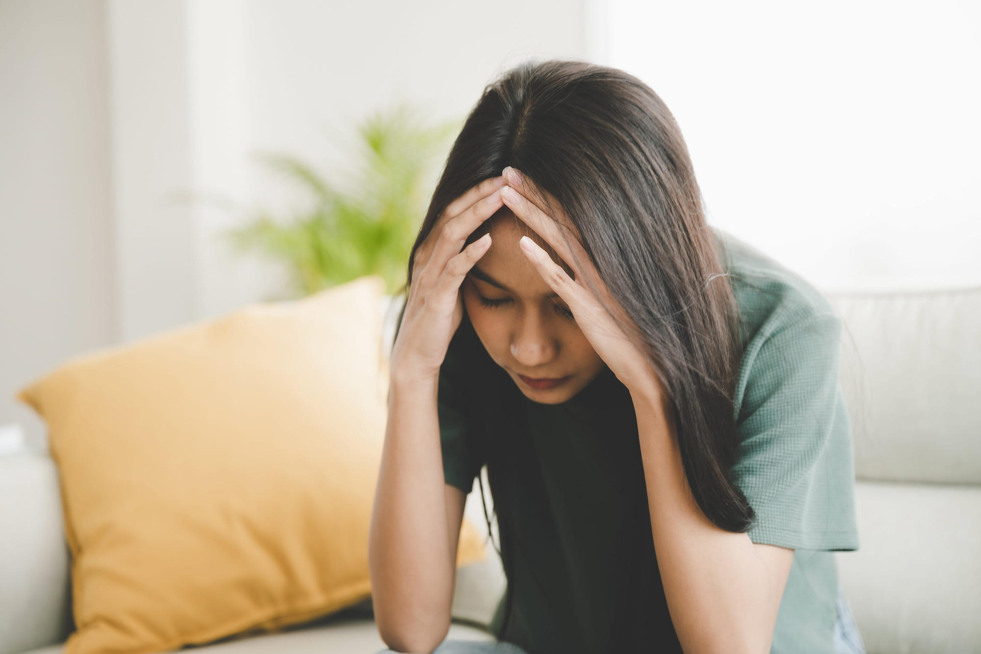Upset woman frustrated by work or relationship problems sitting on couch