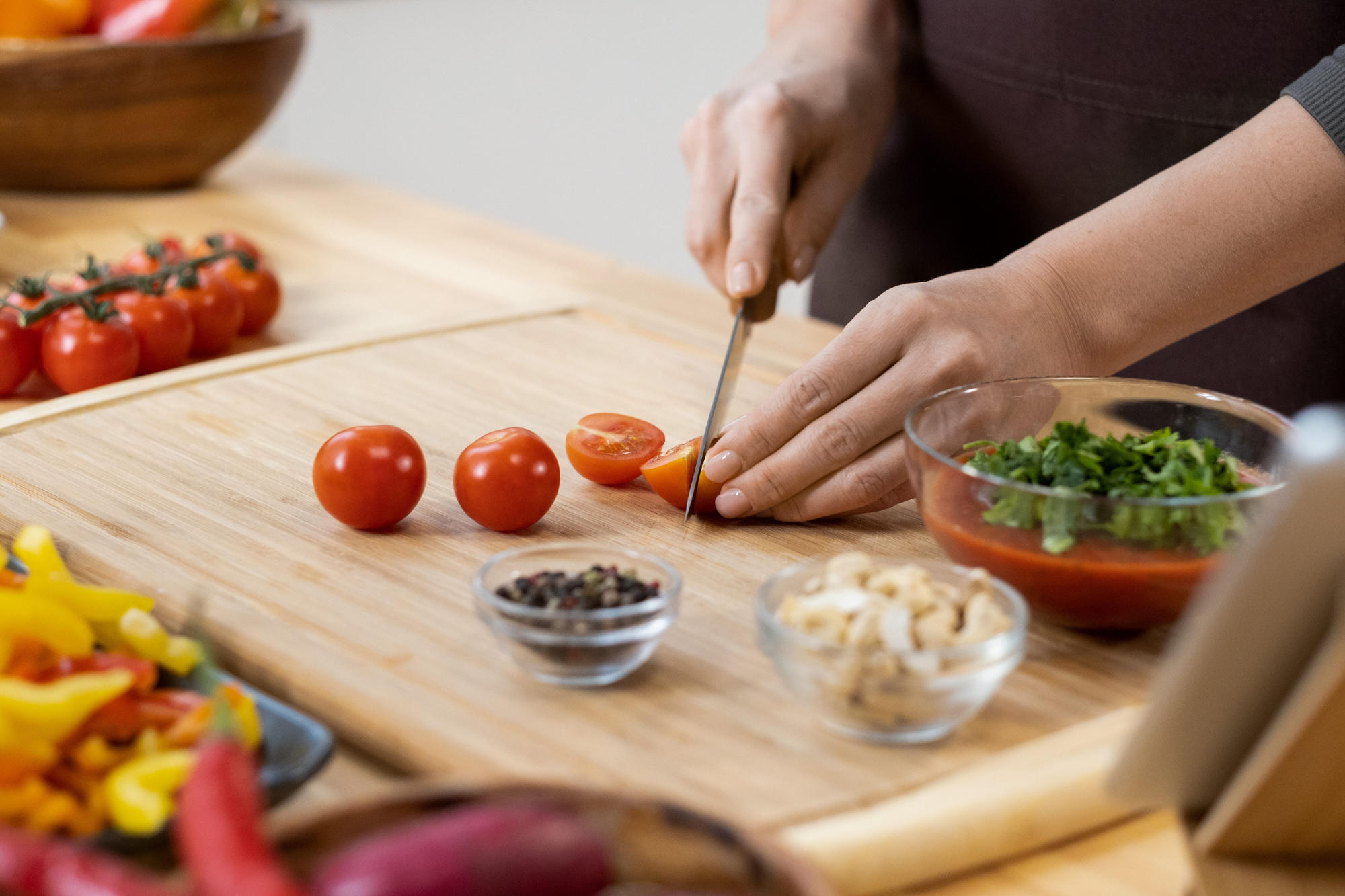 Woman chopping fresh cherry tomatoes for salad