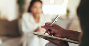 A blurred image of a therapist writing a counseling report for a patient with depression during medication therapy sessions.