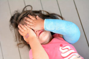 Abused little girl with a broken arm suffering from childhood trauma
