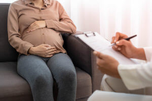 The pregnant mother is discussing depression symptoms during pregnancy with a specialist doctor or psychiatrist.